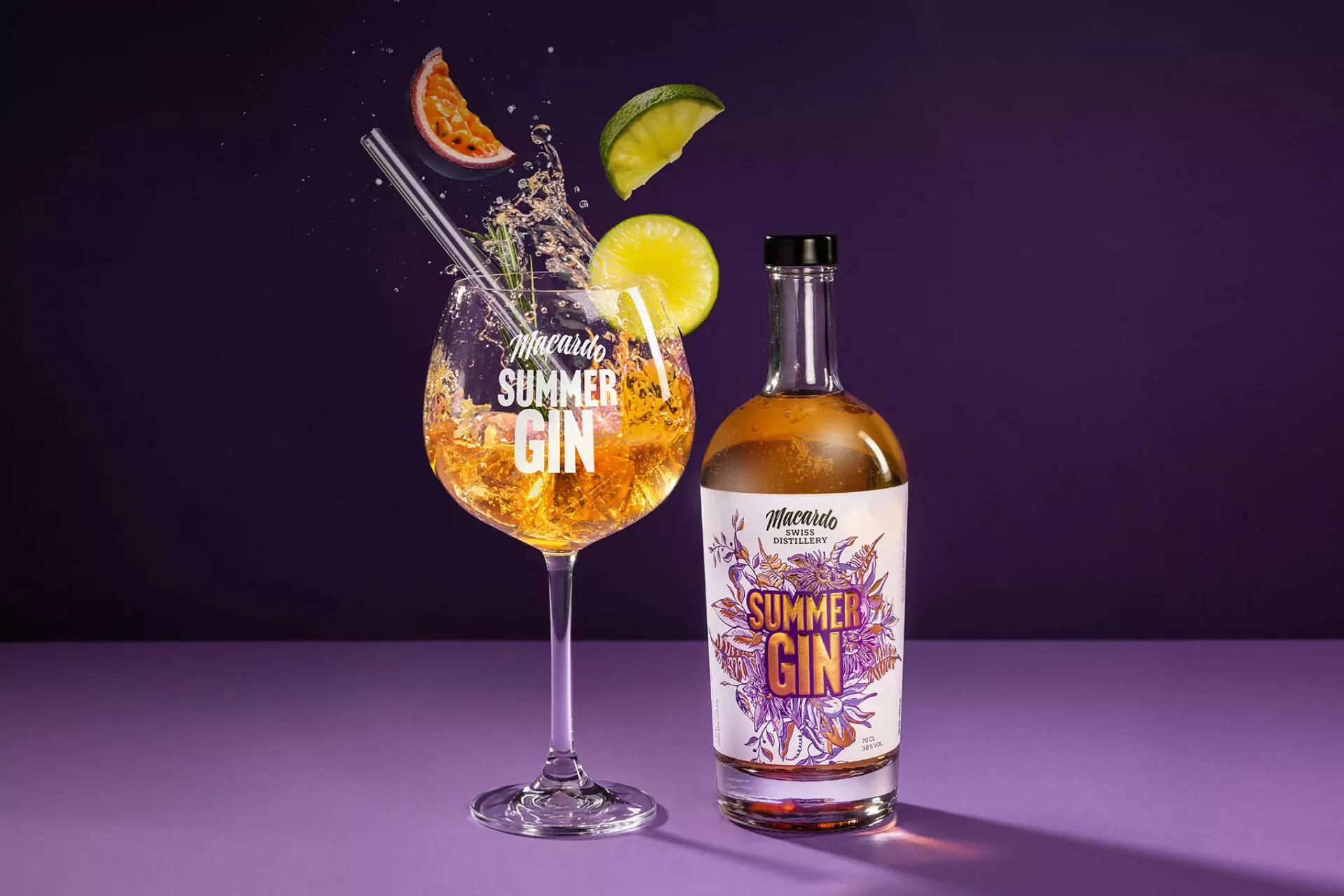 Auf einem violetten Tisch stehen eine Gin-Flasche und ein Gin-Glas. Das Glas hat einen Strohhalm, Eis, Rosmarin und Zitrusfrüchte. Fruchtscheiben fallen in das Glas. Das Etikett auf der Flasche und das Glas zeigen "Summer Gin".